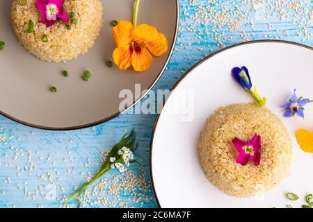 Quinoa-Teller-Präsentation mit essbaren Blumen dekoriert Stockfoto