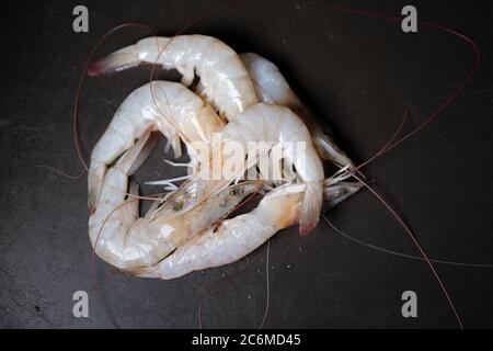 Garnelen auf schwarzem Teller mit Wassertropfen Stockfoto