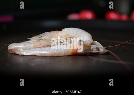 Garnelen auf schwarzem Teller mit Wassertropfen Stockfoto