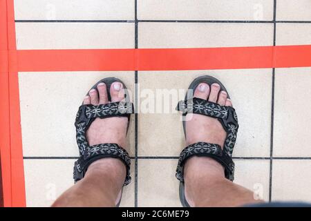 Neuer normaler Lebensstil mit sozialer Distanzierung, bei dem die Menschen durch eine Lücke von mindestens 1 Meter in der Schlange in den Supermarkt in Malaysia getrennt werden Stockfoto