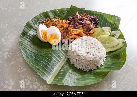 Einfach authentisch einfach Nasi Lemak auf Bananenblatt serviert mit Sambal, Anchovis und Eiern Stockfoto