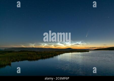 Der Komet Neowise C/2020 F3 leuchtet im Nachthimmel hell durch nächtliche Wolken, wenn er über die Brecon Beacons in South Wales, Großbritannien, Stockfoto