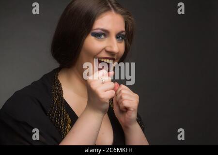 Studio emotionales Porträt einer übergewichtigen Frau. Sie schreit vor Freude und klatscht ihre Fäuste Stockfoto