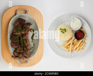 Zwei Teller mit gebratenem Fleisch und Kartoffeln oben isoliert Stockfoto