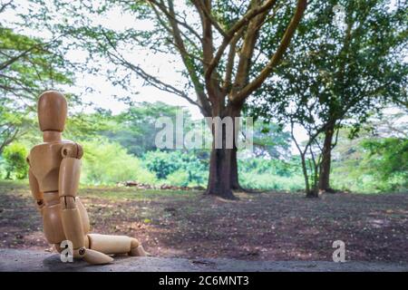 Ein hölzernes menschliches Männchen, das sich im Freien entspannt, Ishasha, Uganda, Afrika Stockfoto