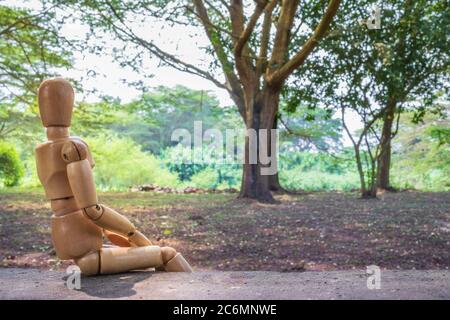 Ein hölzernes menschliches Männchen, das sich im Freien entspannt, Ishasha, Uganda, Afrika Stockfoto