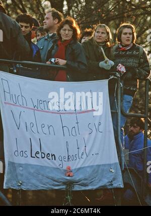 Die westdeutschen Bürger Anzeige ein Banner, wie Sie eine Mahnwache für den Abriss der Berliner Mauer in der Nähe von Brandenburger Tor halten. Ein Teil der Mauer wurde bereits am Potsdamer Platz abgerissen. Stockfoto