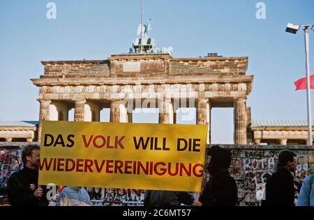 Die westdeutschen Bürger Anzeige ein Banner, wie Sie eine Mahnwache für den Abriss der Berliner Mauer am Brandenburger Tor. Ein Teil der Mauer wurde bereits am Potsdamer Platz abgerissen. Stockfoto