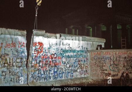 Ein Kran wird ein Abschnitt der Berliner Mauer am Brandenburger Tor. Stockfoto