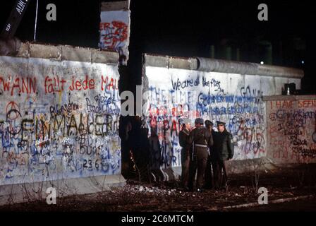 Ost und West deutschen Wachen converse an die neu geschaffene Öffnung der Berliner Mauer nach einem Kran ein Abschnitt der Struktur neben dem Brandenburger Tor entfernt. Stockfoto