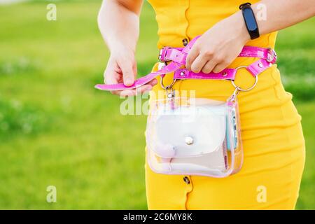 Unkenntlich Frau trendy gelbes Kleid mit transparenter Taillentasche. Modisch elegant lässiges Outfit. Details des Alltagslook. Street Fashion. Nahaufnahme. Platz für Text kopieren Stockfoto