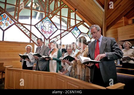 Präsident George W. Bush, verbunden von, von links, erste Dame Barbara Bush, ehemaliger Präsident George H.W. Bush, Barbara Bush, Jenna Welch und Frau Laura Bush, singt eine Hymne Sonntag, 16 April, 2006, beim Ostergottesdienst im Evergreen Kapelle in Camp David im Guymon, Md. Stockfoto