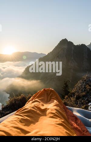 Atemberaubende Aussicht auf den Sonnenaufgang aus dem Schlafsack beim Aufwachen. Stockfoto