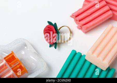 Fimo in verschiedenen Farben. Signet in der Form einer Rose. Auf einer weißen Oberfläche. Kunsthandwerk aus Fimo. Stockfoto