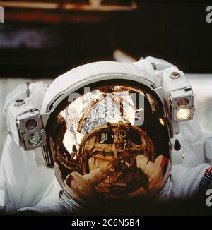 (25. September-6. Oktober 1997) --- das Helmvisier von Astronaut Scott Parazynski reflektiert die Raumfähre Atlantis' Frachtraum-Bucht und Russlands mir-Raumstation sowie den Erdhorizont. Die Astronauten Parazynski und Vladimir G. Titov, beide STS-86-Missionsspezialisten, verbrachten mehrere Stunden damit, mir Environmental Effects Packages (MEEP) zu finden, die seit September 1996 der Weltraumumgebung um das permanente Docking Module (DM) von mir ausgesetzt waren. Titov vertritt die Russische Raumfahrtbehörde (RSA). Stockfoto