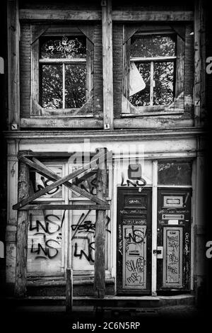 Altes verfallenes verlassenes Kanalhaus in der Stadt Amsterdam Holland schwarz-weiß, monochromes Bild Stockfoto