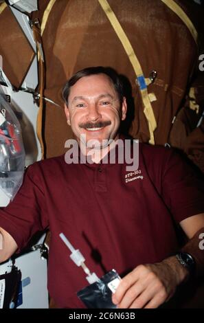 (19-27. Dezember 1999) --- Astronaut Curtis L. Brown Jr., Missionskommandant, auf Discovery's Mitteldeck mit einem Getränkesack. Stockfoto