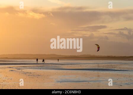 Kiteboarder am Camber Sands, East Sussex bei Sonnenuntergang. Stockfoto