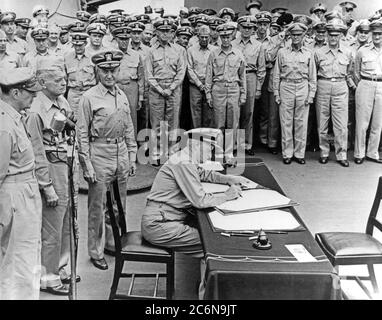 Kapitulation Japans, Tokyo Bay, 2. September 1945. Fuhrpark Adm. Chester W. Nimitz, U.S. Navy, unterzeichnet das Instrument der Kapitulation als Vertreter der Vereinigten Staaten an Bord der USS Missouri (BB-63), 2. September 1945. Direkt hinter ihm stehen (von links nach rechts): General der Armee General Douglas MacArthur; ADM. William F. Halsey, U.S. Navy, und Rear ADM. Forrest Sherman, US Navy. (USA Navy Foto, Foto #: 80-G-701293) Stockfoto