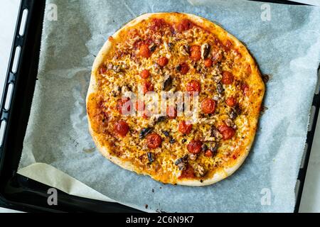 Hausgemachte klassische Original italienische Pizza mit Kirschtomaten und Stracciatella Käse. Traditionelles Fast Food. Stockfoto