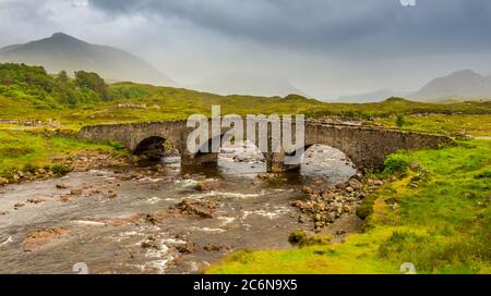 Sligachan Brücke am Fluss Sligachan, an einem bewölkten Sommermorgen auf der Isle of Skye, Schottland, mit den Cuillin Bergen im Hintergrund. Stockfoto