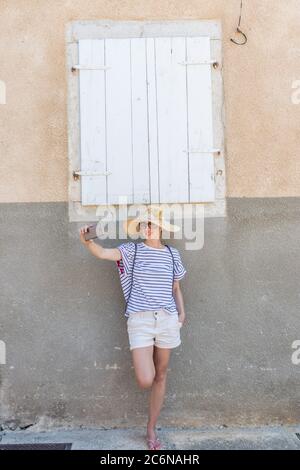 Schöne junge Frau Tourist in großen Strohhut, Selbstporträt Selfie, vor weißen Vinatage Holzfenster und stehen Stockfoto