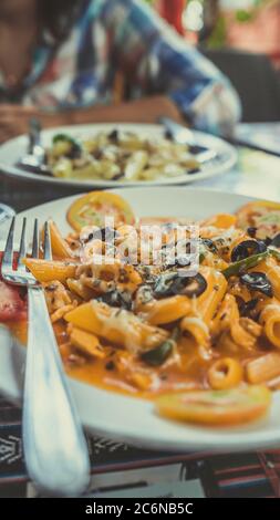 Ein Gericht der Paste mit Meeresfrüchten und Gemüse in einer roten Sauce. Nahaufnahme. Stockfoto