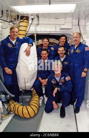 KENNEDY SPACE CENTER, Florida -- auf dem Launch Pad 39A posieren STS-82-Besatzungsmitglieder für ein Gruppenfoto vor dem Eingang zur Crew-Kabine des Space Shuttle Discovery. Vor ihm kniet Mission Specialist Steven A. Hawley. Nutzlast Commander Mark C. Lee ist ganz links. In der zweiten Reihe hinter Hawley, von links, sind die Missionsspezialisten Gregory J. Harbaugh und Steven L. Smith und der Missionskommandant Kenneth D. Bowersox. Hinten, von links, sind die Missionsspezialisten Joseph R. 'Joe' Tanner und Pilot Scott J. 'doc' Horowitz. Stockfoto