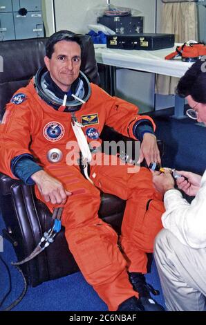 STS-83 Mission Specialist Donald A. Thomas wird bei seinem Start-/Einstiegssachen im Operations and Checkout (O&C) Building unterstützt. Er ist sowohl mit STS-70 als auch mit STS-65 geflogen. Er hat einen Doktortitel in Materialwissenschaften und war der Principal Investigator für ein Space Shuttle Kristallwachstum Experiment. Stockfoto