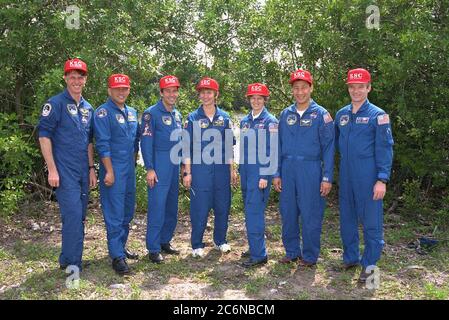 Stolz tragen sie rote KSC-Feuerwehrhüte und halten Mitglieder der STS-84-Crew für einen Moment für ein Gruppenfoto, während sie an den Terminal Countdown Demonstration Test (TCDT)-Aktivitäten teilnehmen. Von links sind die Missionsspezialisten C. Michael Foale, Carlos I. Noriega, Jean-Francois Clervoy von der Europäischen Weltraumorganisation und Elena V. Kondakova von der Russischen Weltraumorganisation; und die Pilot Eileen Marie Collins, der Missionsspezialist Edward Tsang Lu und Kommandant Charles J. Precourt. Stockfoto