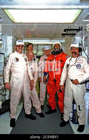 STS-87 Mission Specialist Winston Scott posiert in seinem orangen Start- und Einstiegspacesuit mit NASA-Anzugstechnikern auf dem Launch Pad 39B während der Terminal Countdown Demonstration Test (TCDT)-Aktivitäten. Stockfoto