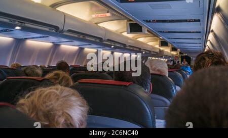 Moskau, Russland 18. Dezember 2019: Die Rückansicht der vielen Menschen im Flugzeug. Innenraum des Flugzeugs mit Passagieren, sitzen auf Sitzen. Das Konzept Stockfoto