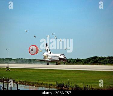 Eine Vogelschar fliegt, als der Orbiter Columbia mit seiner Schlepprutsche auf der Start- und Landebahn 33 der KSC Shuttle Landing Facility landet, um die fast 16-tägige STS-90 Mission abzuschließen. Der Hauptzahnradauftaster war am 3. Mai 1998 um 12:08:59 Uhr EDT und landete auf der Umlaufbahn 256 der Mission. Die Räder stoppten um 12:09:58 Uhr EDT und absolvten eine Gesamteinsatzzeit von 15 Tagen, 21 Stunden, 50 Minuten und 58 Sekunden. Stockfoto