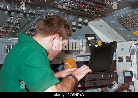 (12. Januar 1997) --- an Bord des Space Shuttle Atlantis beginnt Astronaut John M. Grunsfeld, Missionsspezialist, an seinem ersten Tag im Orbit für die Mission, Missionsdaten auf einem Laptop-Universalcomputer einzugeben. Grunsfeld und fünf Besatzungskollegen fliegen das Spacehab Double Module (DM), das mit Hilfsgütern für die drei-Mann-Besatzung an Bord der russischen mir-Raumstation ausgestattet ist, mit der Atlantis später in der Woche andocken wird. Die Szene wurde mit einer elektronischen Standkamera (ESC) aufgenommen und später mit Flugsteuerungen in Houston, Texas, herunterverbunden. Stockfoto