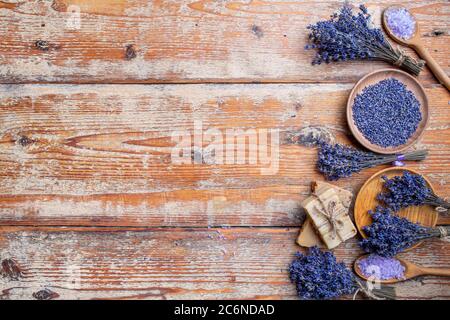 Flache Lay-Komposition mit handgefertigten Seifenstücken, Badesalz und Lavendel mit Platz für Text auf Holzgrund Stockfoto