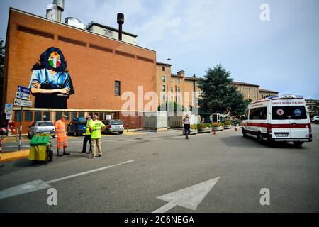 Padua, Italien. Die Straßenkünstlerin Alessio-B malt ein Porträt von Wonder Woman, gekleidet als Ärztin in einem weißen Mantel, einer chirurgischen Trikolormaske und dem Stethoskop an einer Wand des Krankenhauses in Padua, zu Ehren aller Ärztinnen und Krankenschwestern, die in italienischen Krankenhäusern gegen Covid 19 kämpfen. Stockfoto