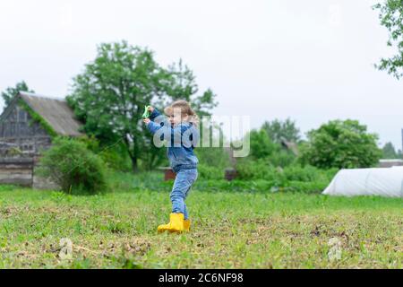 Kleines Mädchen im Dorf startet Kite. Landleben Stockfoto