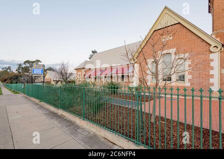 Mudgee Public School wurde 1872 erbaut und 1928 erweitert. Es ist von gotischem und romanischem Stil und aus Ziegelstein und einem Wellblech-Dach gebaut Stockfoto