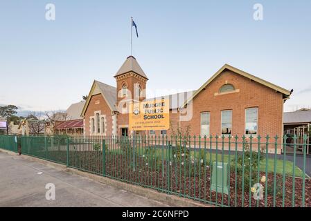 Mudgee Public School wurde 1872 erbaut und 1928 erweitert. Es ist von gotischem und romanischem Stil und aus Ziegelstein und einem Wellblech-Dach gebaut Stockfoto