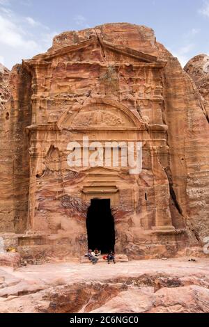 Petra, Jordanien - 20. April 2014: Jordanische Beduinenkinder spielen vor der Tür einer antiken Tempelruine im Tal von Petra, Jordanien Stockfoto