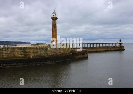 Blick auf Whitby's West Lighthouse und den Pier im Hintergrund. Whitby, North Yorkshire, England, Großbritannien. Stockfoto
