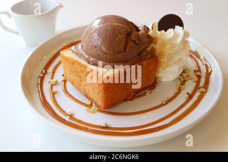 Honig Butter Ahornsirup Toast mit Schokolade Eis serviert auf weißem Tisch Stockfoto