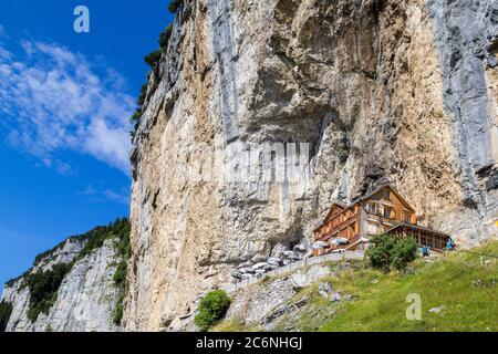 Ebenalp, Schweiz - 09. August 2019 : das Gästehaus Aescher - Wildkirchli gegen die Ascher Klippe auf der Ebenalp über den Schweizer Alpen in Stockfoto