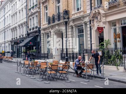 Ein Mann, der während der Pandemie des Covid-19 vor einem Restaurant in Covent Garden, London, serviert wurde. Stockfoto