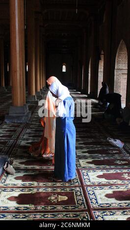 Frauen, die Gebete im historischen Jamia Masjid in Srinagar anbieten. Jamia Masjid, das 1400 n. Chr. erbaut wurde, liegt in Nowhatta, mitten in der Altstadt in der Hauptstadt Srinagar. Die historische Moschee wurde von Sultan Sikandar erbaut. Später wurde die Moschee durch den Sohn des Sultans Sikandar, Zain-ul-Abidin, erweitert. Die Attraktionen des Jama Masjid umfassen wunderschöne indo-sarakische Architektur, einen herrlichen Innenhof und 370 Holzsäulen. Ein weiteres Merkmal der Moschee ist die Ruhe und Stille in ihr, die sich gegen das Treiben der alten Basare um sie herum. Hunderte von Muslimen versammeln sich Stockfoto