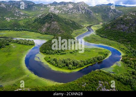Luftaufnahme der Flussbiegung des Flusses Rijeka Crnojevica und See Skadar, Blick vom Aussichtspunkt, mit Drohne in der Nähe von Cetinje genommen Stockfoto