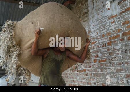 Dhaka, Dhaka, Bangladesch. Juli 2020. Arbeiter tragen am 11. Juli 2020 in einer Jute-Verarbeitungsfabrik in Narayanganj bei Dhaka, Bangladesch, Verarbeitungsjute. Kredit: Zabed Hasnain Chowdhury/ZUMA Wire/Alamy Live Nachrichten Stockfoto