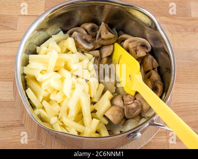 Strohkartoffeln, gebratene Pilze mit Zwiebeln in einer Pfanne. Cremesuppe Zum Kochen. Stockfoto