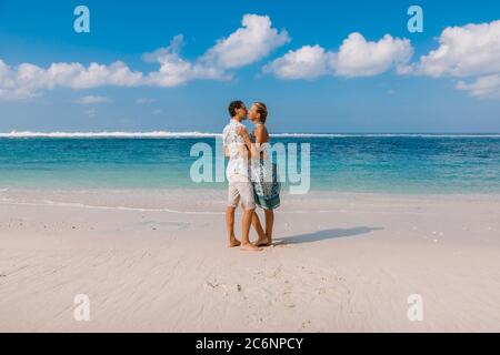 Junge schwangere Frau mit Mann entspannen im Paradies Strand. Glückliches Paar in den Tropen Stockfoto