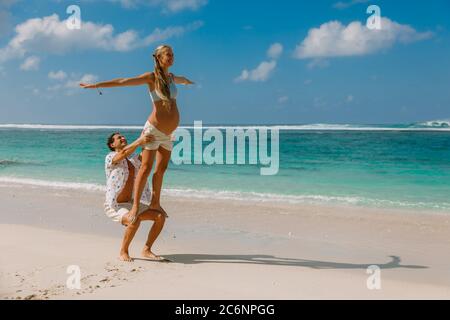 Junge schwangere Frau mit Mann entspannen im Paradies Strand. Glückliches Paar in den Tropen Stockfoto